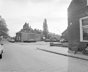 882110 Gezicht op een braakliggend terreintje op de hoek van de Hogelanden W.Z. en de Okkernootstraat (rechts) te ...